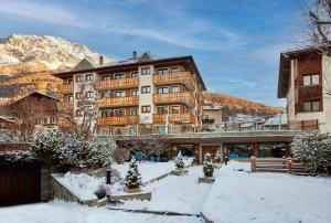 ein Hotel in den Bergen mit Schnee auf dem Boden in der Unterkunft Hotel Rezia in Bormio