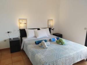 a bedroom with a bed with two stuffed animals on it at Casa La Ola Majanicho - Monthly Stays in Majanicho +51 photos