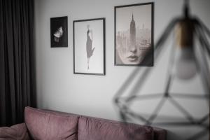 a living room with a couch and pictures on the wall at Home sweet home, cozy apartments, free underground parking, long stays welcome in Vilnius