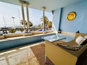 a living room with a glass table and a balcony at Apartamento Puerto Sotogrande in Sotogrande