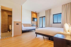 a hotel room with two beds and a bathroom at Hotel Acta Madfor in Madrid