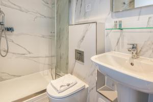 Un baño con lavabo, inodoro y ducha. en Princes Square, en Londres