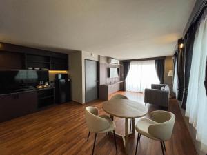 a living room with a table and chairs and a kitchen at We Hotel in Ban Bang Toei (1)
