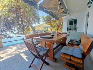 a wooden table and a chair on a patio at Robinson House Destina in Bogomolje