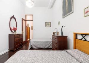 a bedroom with two beds and a dresser and a mirror at Emblematic House in Santa Cruz de La Palma in Santa Cruz de la Palma