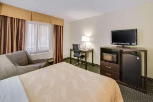 a hotel room with a bed and a flat screen tv at Quality Inn & Suites Sioux Falls South in Sioux Falls