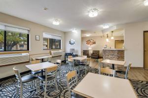 a restaurant with tables and chairs and a fireplace at Quality Inn & Suites Sioux Falls South in Sioux Falls
