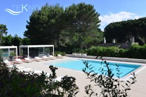 a swimming pool with chaise lounge chairs and a swimming pool at Villa Rosato in Selva di Fasano