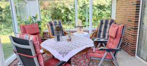a table and four chairs on a screened porch at Ferienhaus "Haus Bethlehem" Käthe Schmidt in Papenburg +9 photos