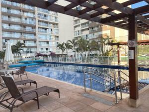 a swimming pool with two chairs next to a building at Blend Apartments in Brasília