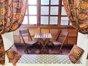 a room with two chairs and a table and a window at Treasures of Zanzibar House in Zanzibar City