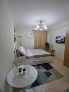 a small bedroom with a bed and a table at Mountain View Studio at Marina Spatial - 300Mbps, Pool, City Centre in Dumaguete +14 photos