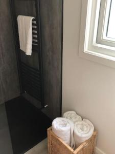 un bagno con tre cesti di asciugamani e una doccia di Luxury 1 bedroom Glamping Cabin with Hot Tub & BBQ a Ballyvoy Altre 22 foto