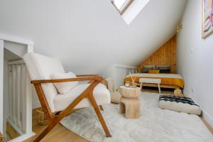 a living room with a chair and a bed at Jacuzzi Sauna privatif - La Cabanette Spa in Saint-Maur-des-Fossés