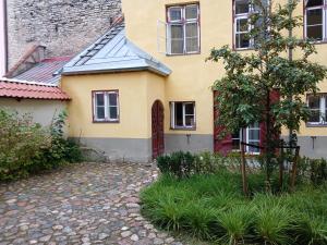 une maison jaune avec un chemin devant elle dans l'établissement Budget nest, à Toompea