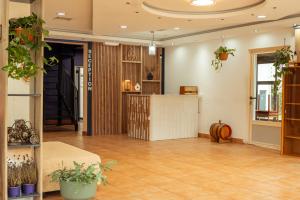 a lobby with a counter in a room with plants at Bujtina Podguri Authentic Stay with Breakfast and Parking in Peje