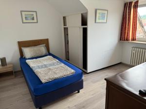 a bedroom with a blue bed and a window at Gästehaus Bavaria in Marktheidenfeld