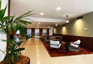 a lobby with a couch and a chair and a plant at Sudima Auckland Airport in Auckland