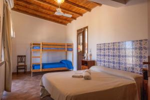 ein Schlafzimmer mit einem Bett und einem Etagenbett in der Unterkunft Fattoria Manostalla Villa Chiarelli in Balestrate