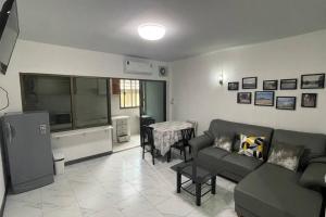 ein Wohnzimmer mit Sofa und Fernseher in der Unterkunft Manoo House E in Pratunam