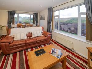 ein Wohnzimmer mit Sofa und Tisch in der Unterkunft Fenny Marina Cottage in Southam