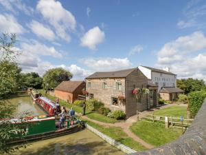 ein schmales Boot auf einem Kanal vor einem Gebäude in der Unterkunft Fenny Marina Cottage in Southam