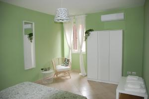 a bedroom with a bed and a chair and a window at Castrum Home - Castelli Apartments in Castel Gandolfo