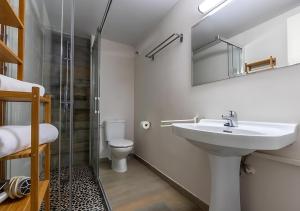 a bathroom with a sink and a toilet and a mirror at Apartamentos Wundermar in Torredembarra