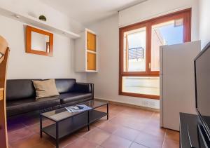 a living room with a black couch and a table at Apartamentos Wundermar in Torredembarra