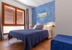 a bedroom with a bed and a blue wall at Apartamentos Wundermar in Torredembarra