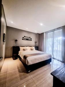 a bedroom with a large bed and a large window at Hyarta Villa 3 BR Block C in Kejayan