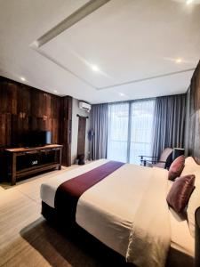 a bedroom with a large bed and a television at Hyarta Villa 3 BR Block C in Kejayan +6 photos