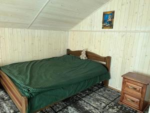 a bedroom with a bed with a teddy bear sitting on it at Cottage 'Carolina' with hot tub, sauna and BBQ area in Kosiv