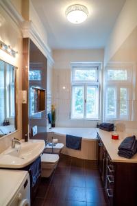een badkamer met een bad, een toilet en een wastafel bij Residence Oasis in Győr