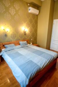 een slaapkamer met een groot bed met blauwe lakens bij Residence Oasis in Győr