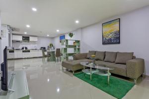 a living room with a couch and a table and a kitchen at Grosvenor House - Olympic Pool - Pattaya in Pattaya South
