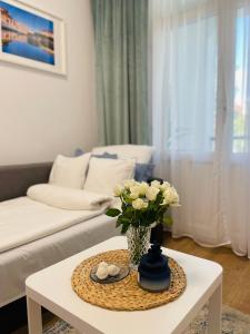 salon z wazą kwiatów na stole w obiekcie MINI Chrobrego przy plaży z Loggia w mieście Sopot