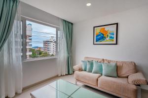 a living room with a couch and a large window at Grosvenor House - Olympic Pool - Pattaya in Pattaya South