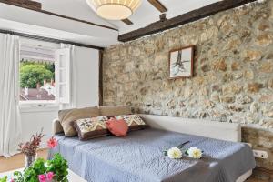 SeloresにあるApartamento 3のベッドと石の壁のある寝室