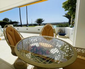 a glass table and two chairs on a balcony at Seaview Bungalow Duna Golf in Playa del Ingles