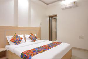 Postel nebo postele na pokoji v ubytování FabHotel Shree Haree Residency - Nr Mazda Garden View