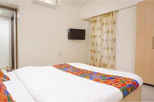 Postel nebo postele na pokoji v ubytování FabHotel Shree Haree Residency - Nr Mazda Garden View