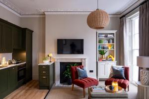 a living room with two chairs and a fireplace at 5&6 North Place in Gloucestershire