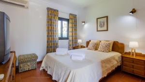 a bedroom with a bed and a television in it at Greice Homes-650 meters from the beach, 4 bedrooms villa for holidays in Vilamoura-Quarteira in Quarteira +19 photos
