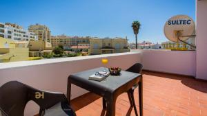 a table and chairs on a balcony with a view at Greice Homes-650 meters from the beach, 4 bedrooms villa for holidays in Vilamoura-Quarteira in Quarteira