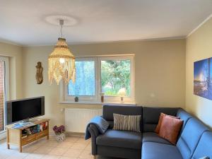 a living room with a blue couch and a tv at Ferienhaus VogelMeer in Marlow