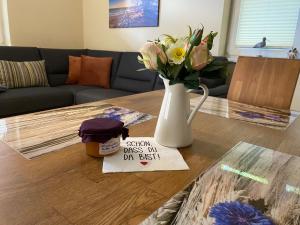 a table with a vase of flowers and a sign on it at Ferienhaus VogelMeer in Marlow