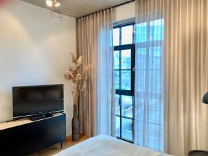 a bedroom with a television and a large window at Exclusive apartment in Heart of Town in Vanalinn