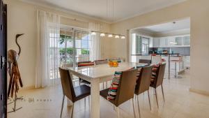 a kitchen and dining room with a table and chairs at Luxuosa moradia V5 em Quarteira - Greice Homes in Quarteira