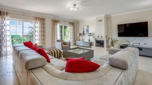 a large living room with a large couch with red pillows at Luxuosa moradia V5 em Quarteira - Greice Homes in Quarteira